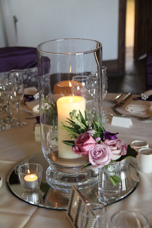 there is a candle that is on the table with some flowers and candles in it