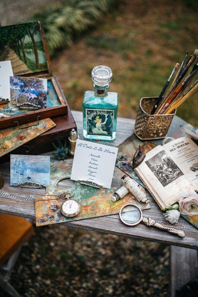 an assortment of art supplies sitting on top of a wooden table next to other items