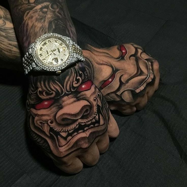 a tattooed hand with a watch on it