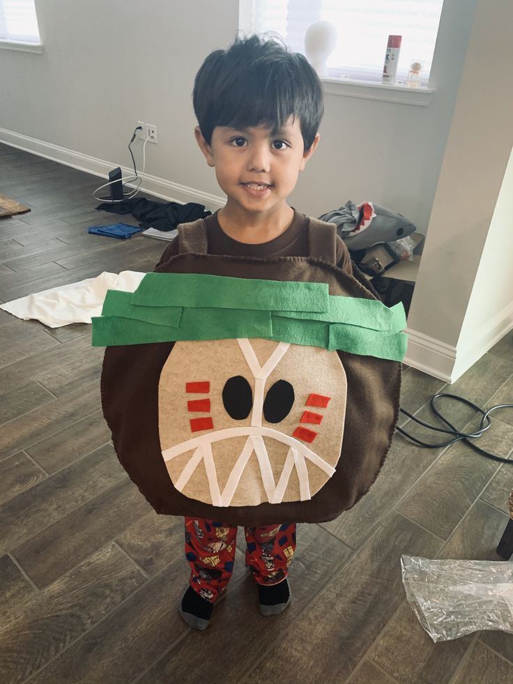 a young boy wearing a paper bag with a monkey on it's head and eyes