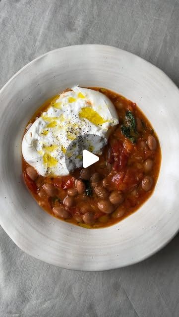 a white plate topped with beans and an egg