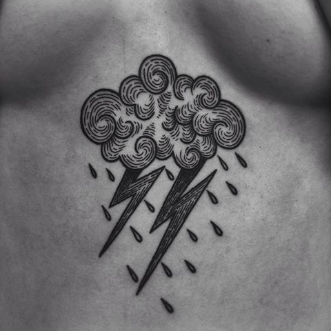 a black and white photo of a man's chest with a lightning tattoo on it