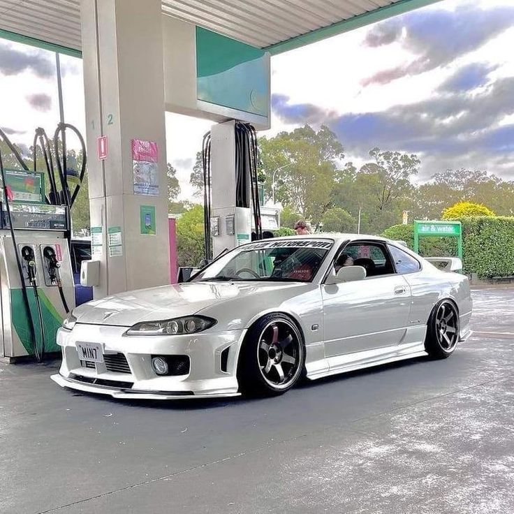 a white car parked in front of a gas station