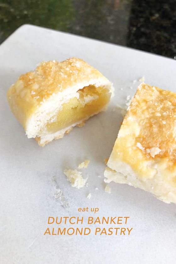 two pieces of bread sitting on top of a piece of white paper with the words dutch bakery almond pastry