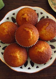 four muffins on a white plate sitting on a table