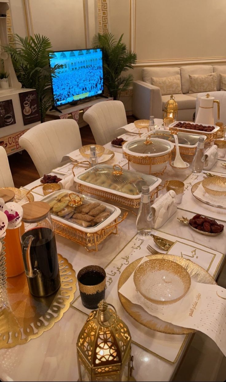 a dining room table is set with gold plates and place settings for two people to eat