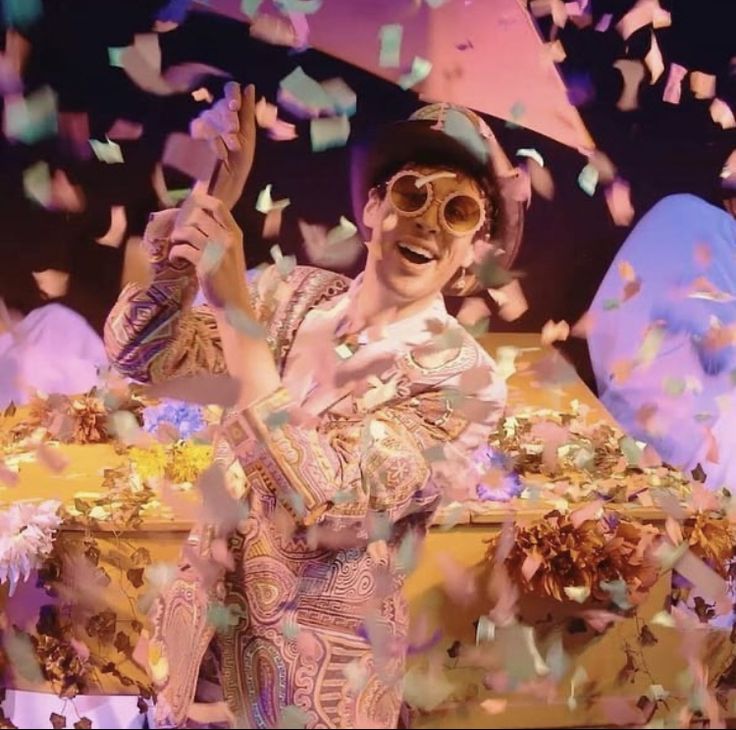 a woman is standing in front of some confetti