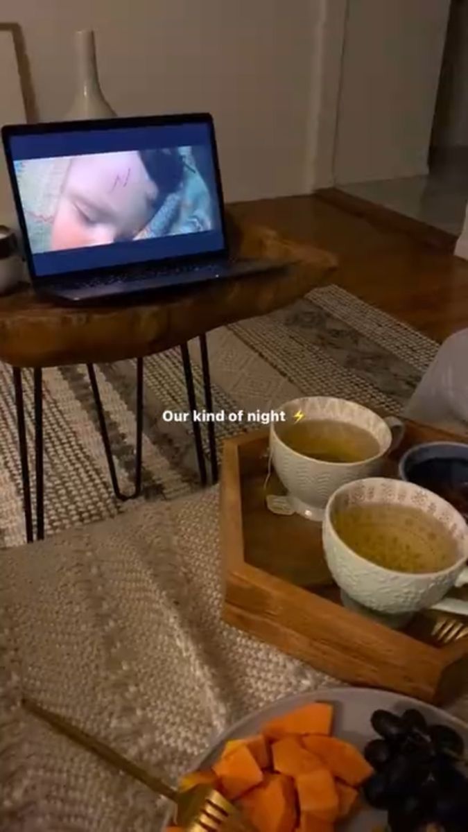 a laptop computer sitting on top of a table next to bowls of food and utensils