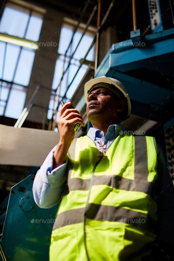 a construction worker is talking on his cell phone - stock photo - images and clippings