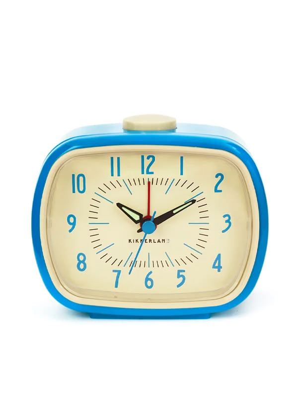 a blue and white alarm clock sitting on top of a table