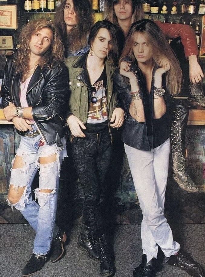 the group of young men are posing for a photo in front of a liquor store