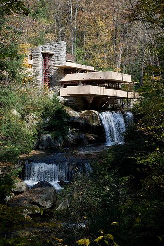 the falling house is surrounded by trees and rocks, with a waterfall running through it