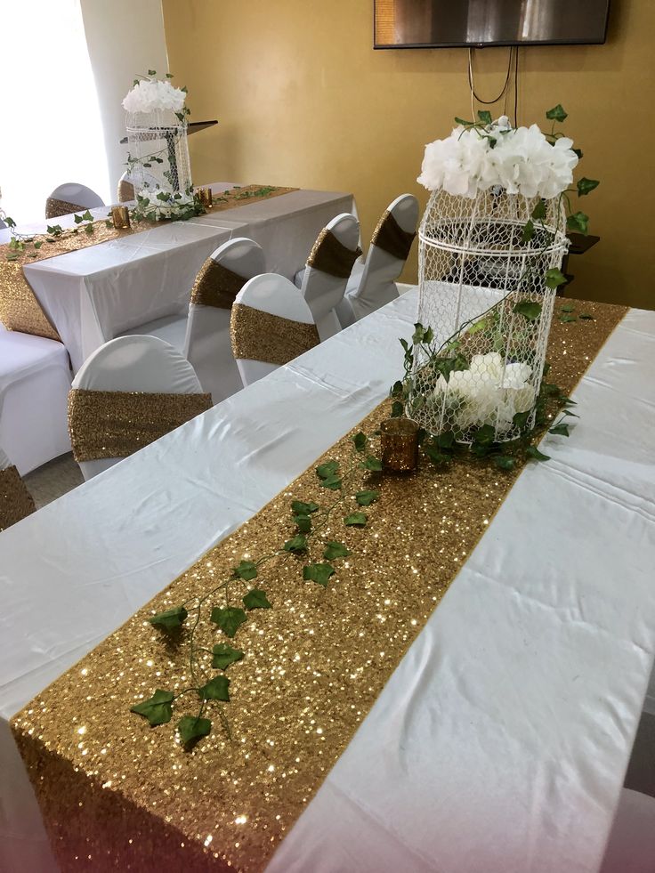 the table is decorated with white flowers and gold sequins