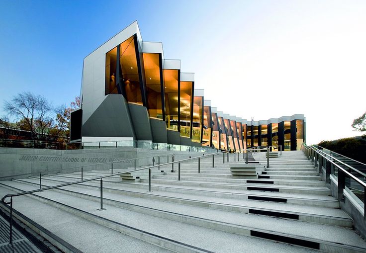 the building is made of glass and has stairs leading up to it