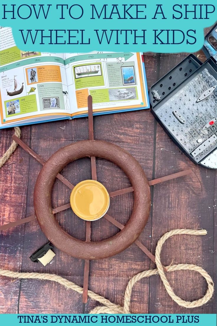 an open book sitting on top of a wooden table next to a steering wheel and other items