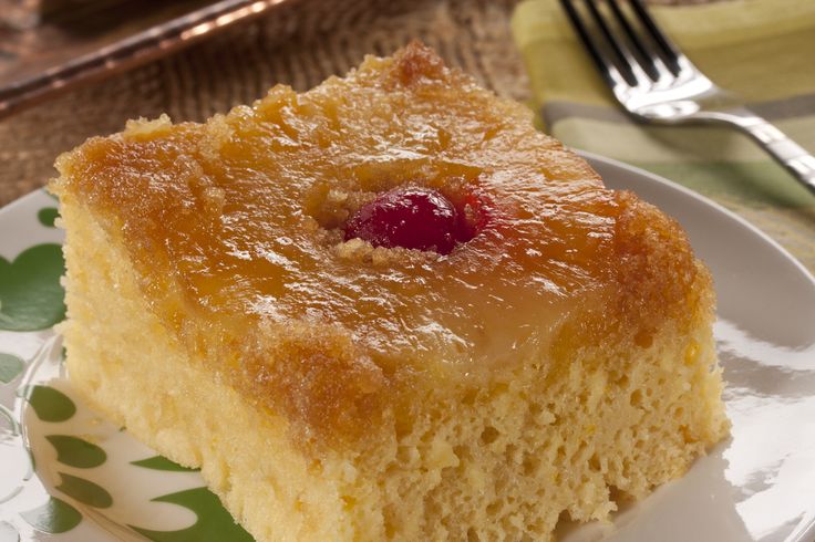 a piece of pineapple upside down cake on a plate with a fork next to it