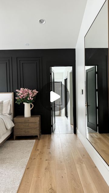 a bedroom with black walls and wooden floors