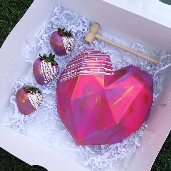 a pink heart shaped box with strawberries in it