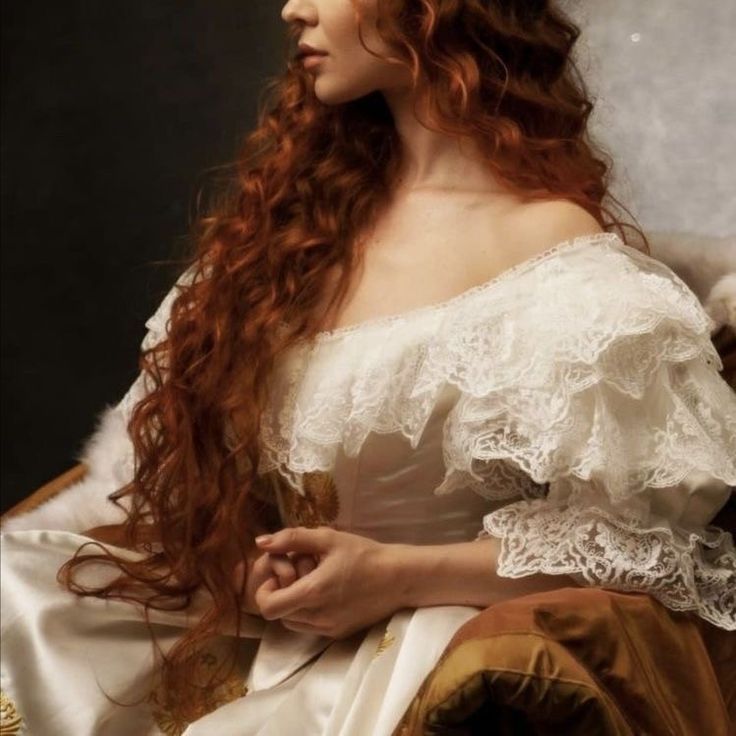 a woman with long red hair wearing a white dress