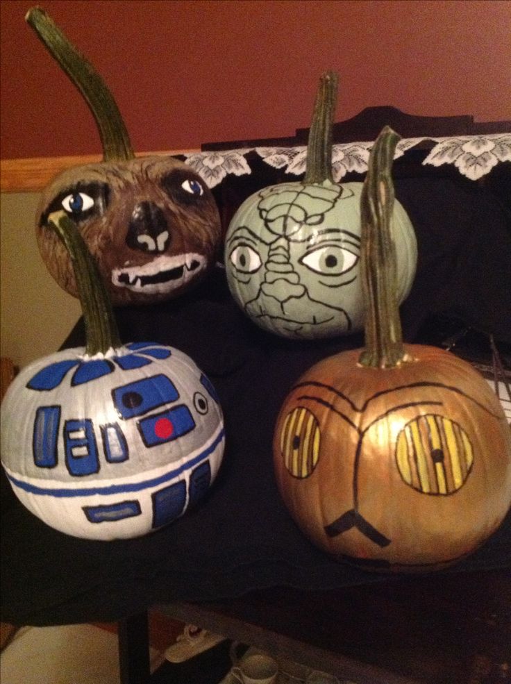 three star wars pumpkins with faces painted on them