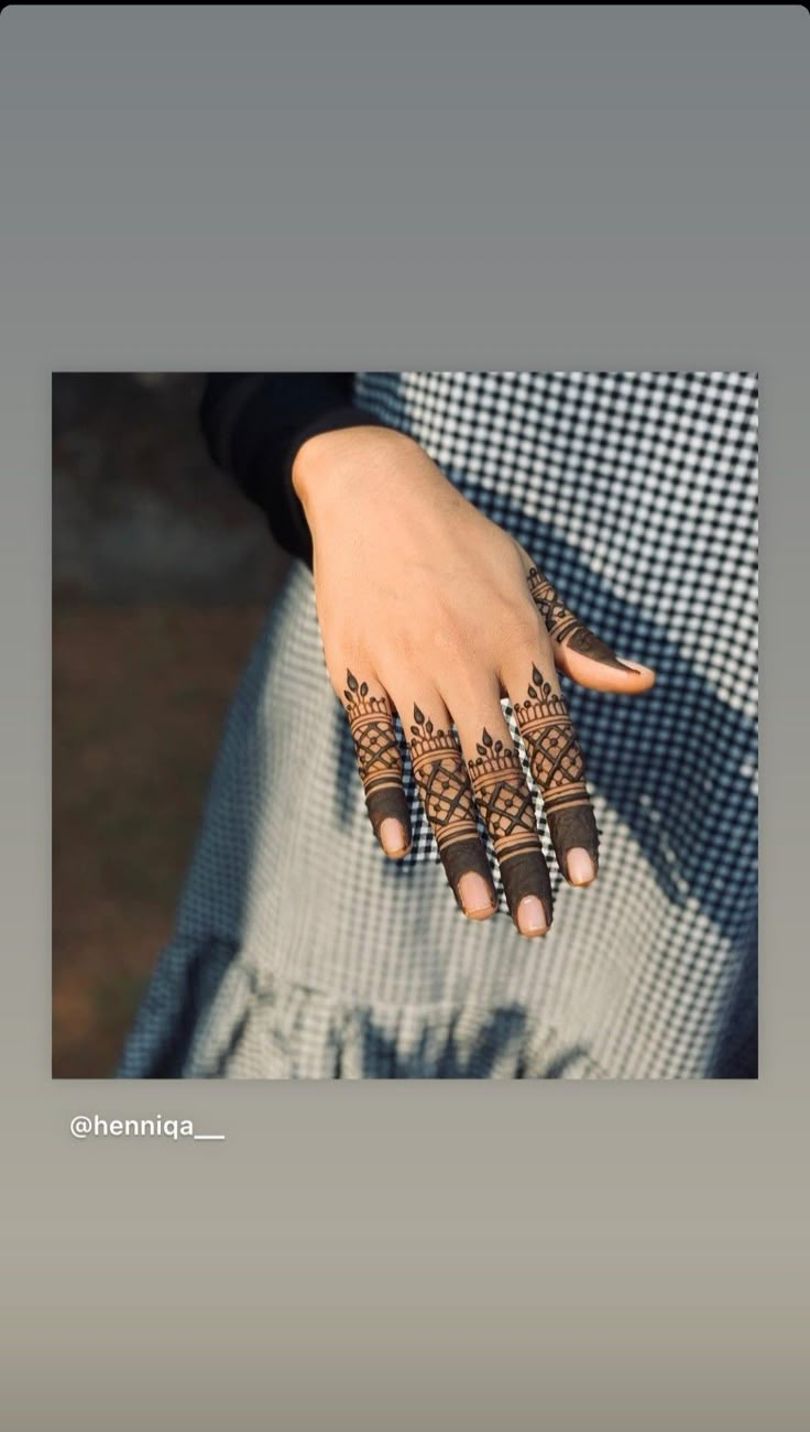 a woman's hand with henna tattoos on it