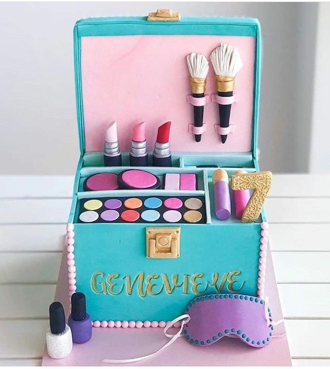 a cake shaped like an open suitcase with makeup and accessories in it on a table