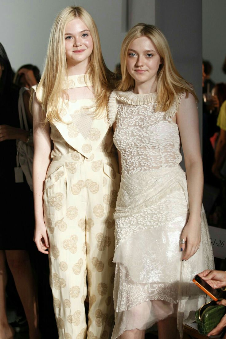 two women standing next to each other at a fashion show