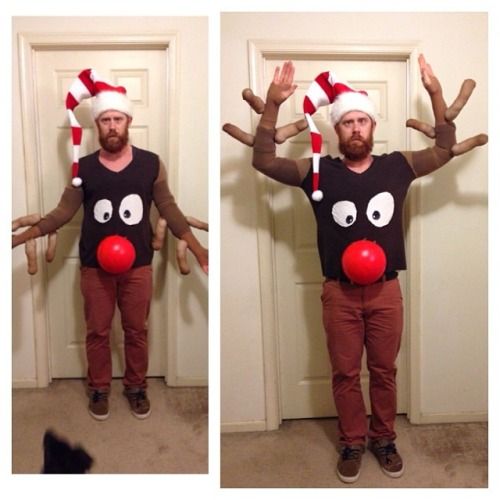 the man is wearing reindeer hats and standing in front of a door with his hands up