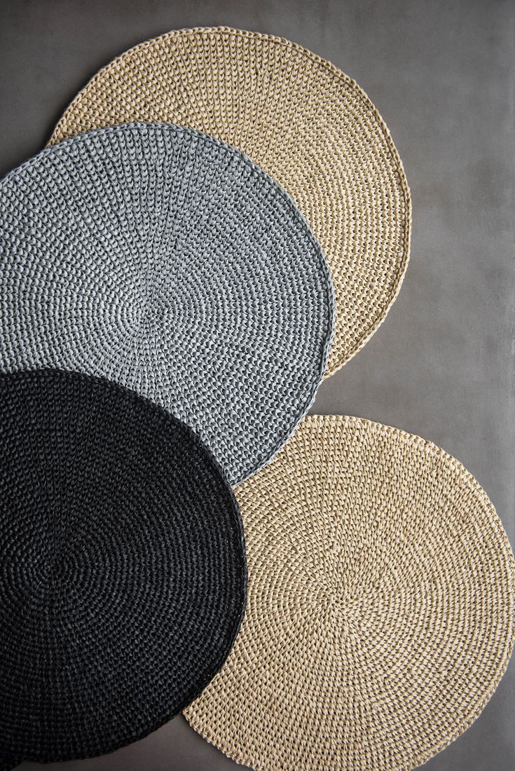 three woven placemats on top of each other in different colors and sizes,