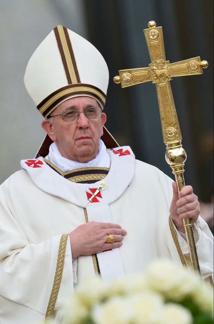 a man in a priest's outfit holding a cross