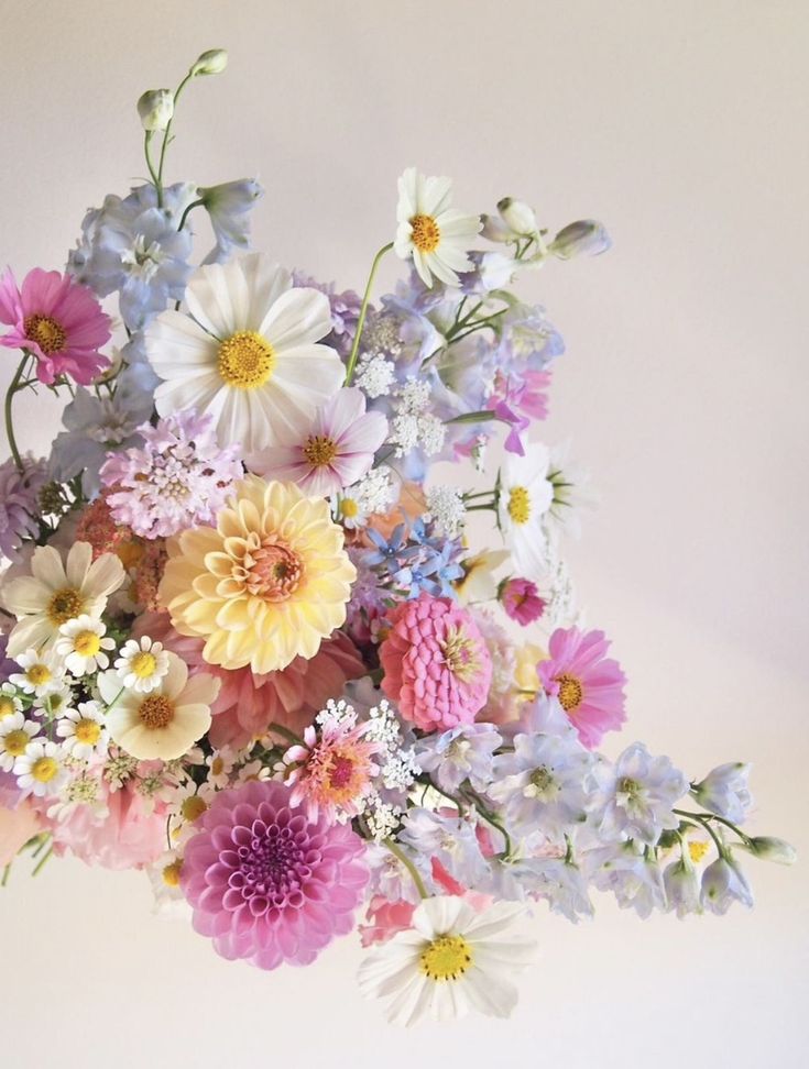 a vase filled with lots of different colored flowers