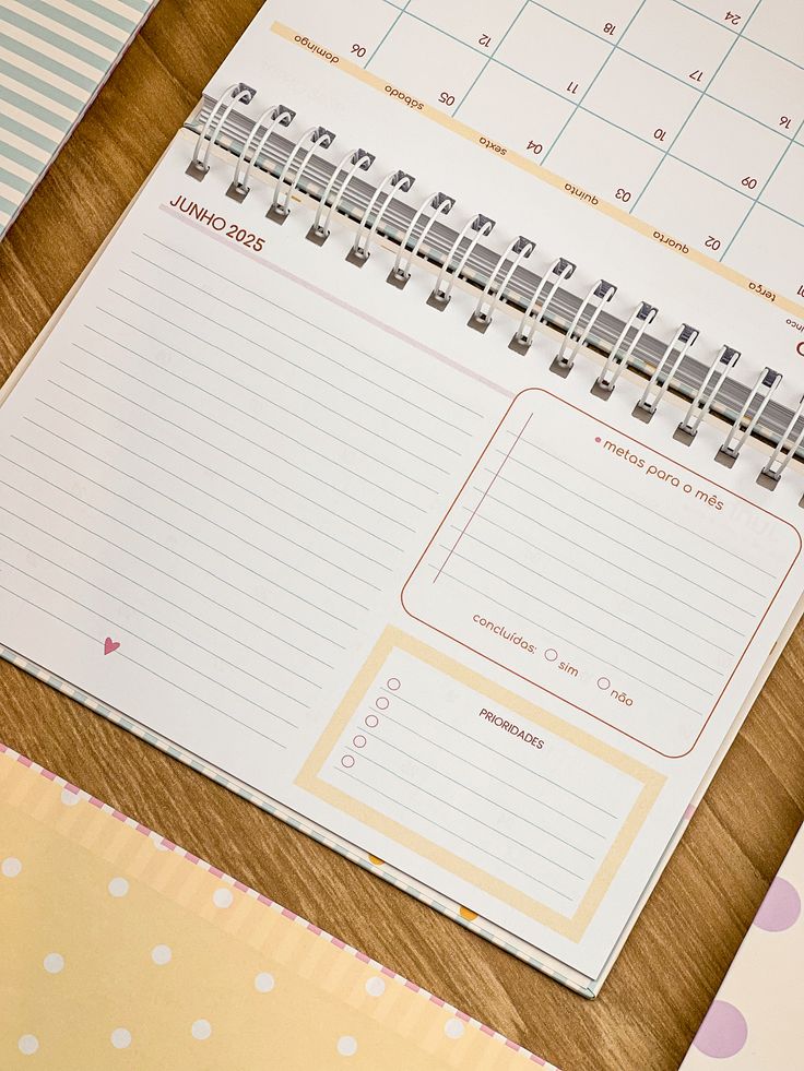 a desk with two calendars on top of it next to a pen and paper