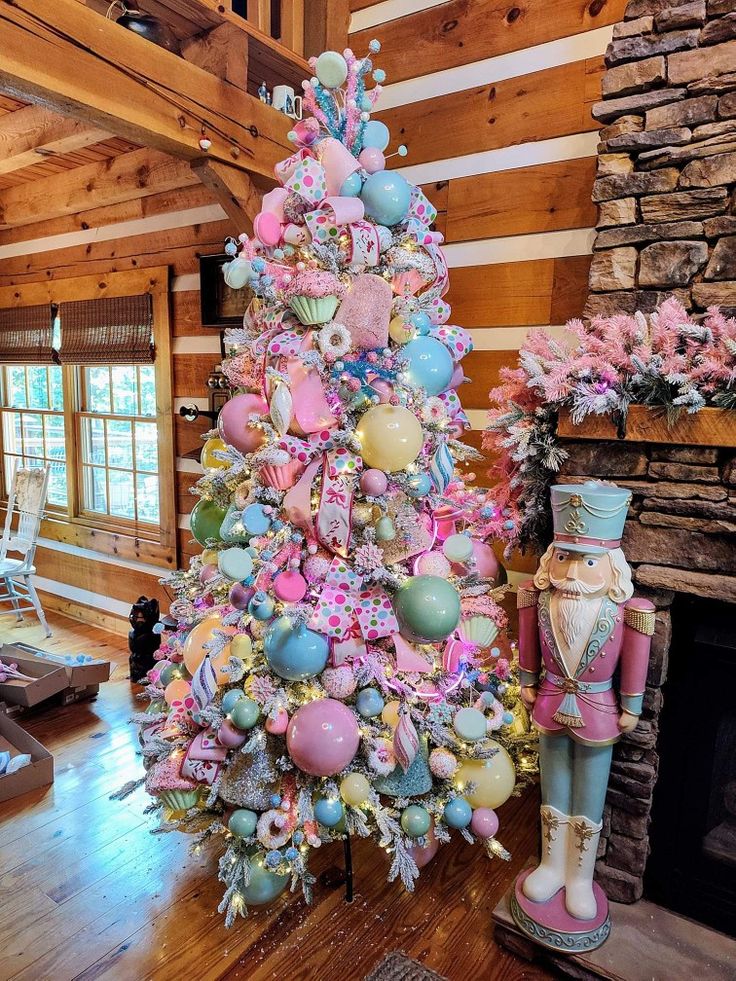 a pink and blue christmas tree in a living room with other decorations on the floor