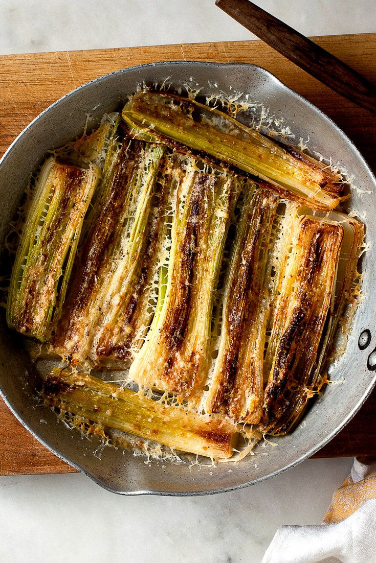 a pan filled with cooked zucchini on top of a wooden cutting board