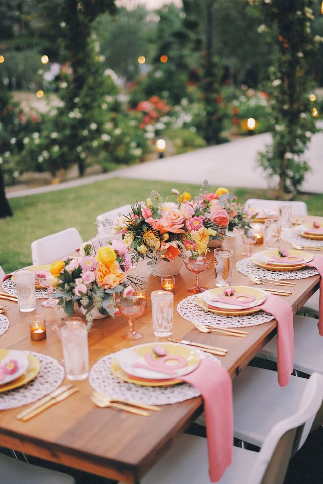 a table set with plates and place settings for an outdoor dinner party in the backyard