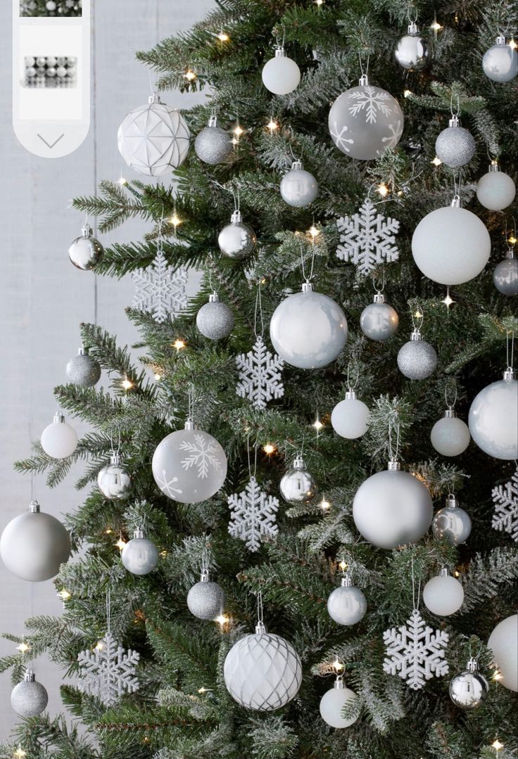 a christmas tree with white and silver ornaments