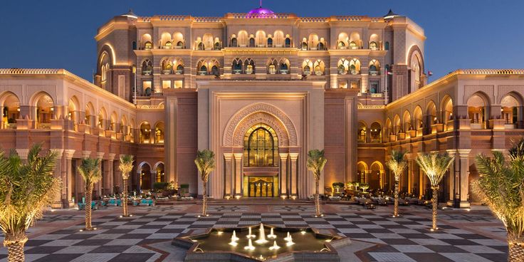 an elaborately decorated building with fountains in the middle and palm trees on either side