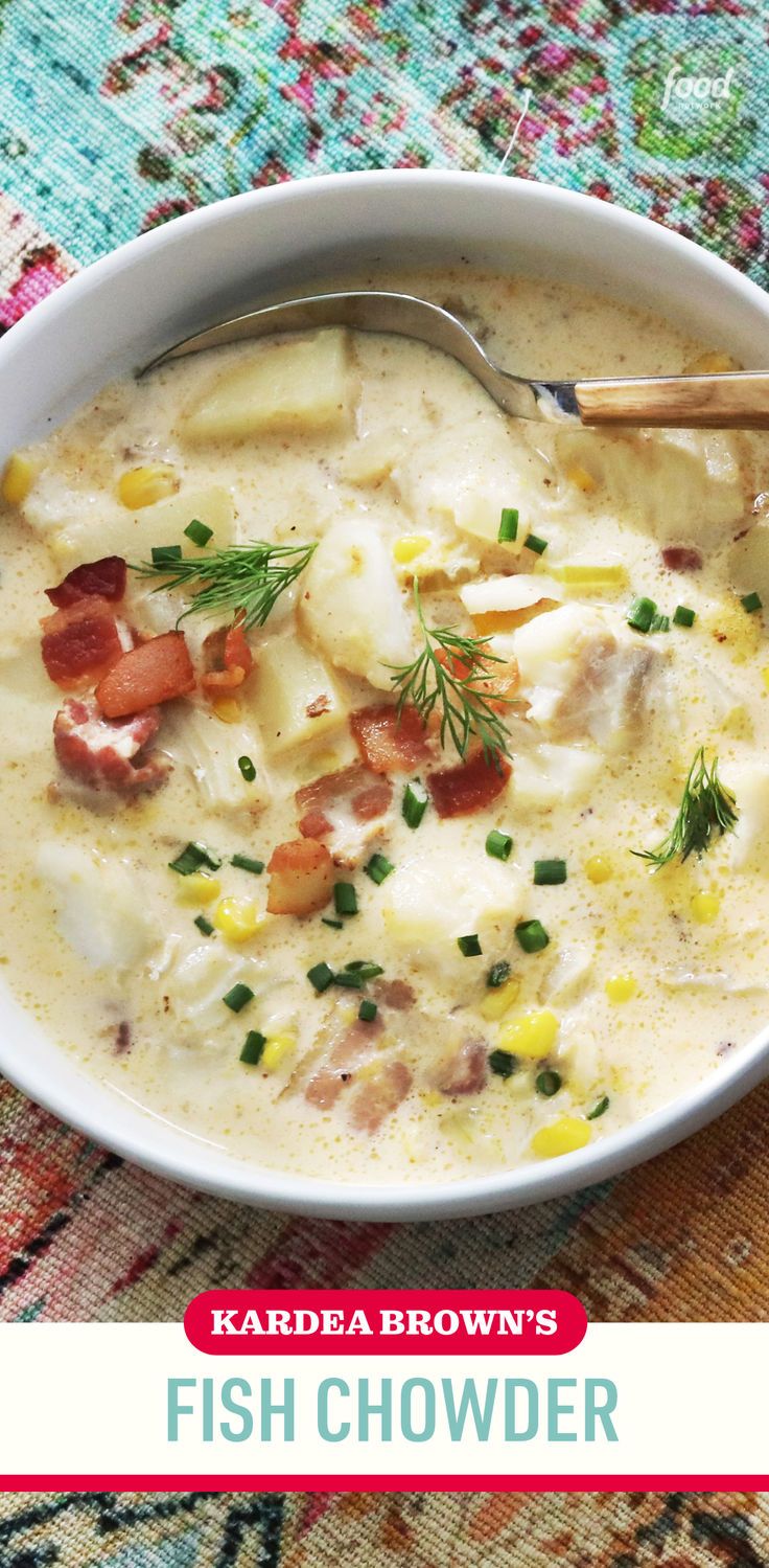 a bowl of fish chowder with a spoon in it on a colorful table cloth