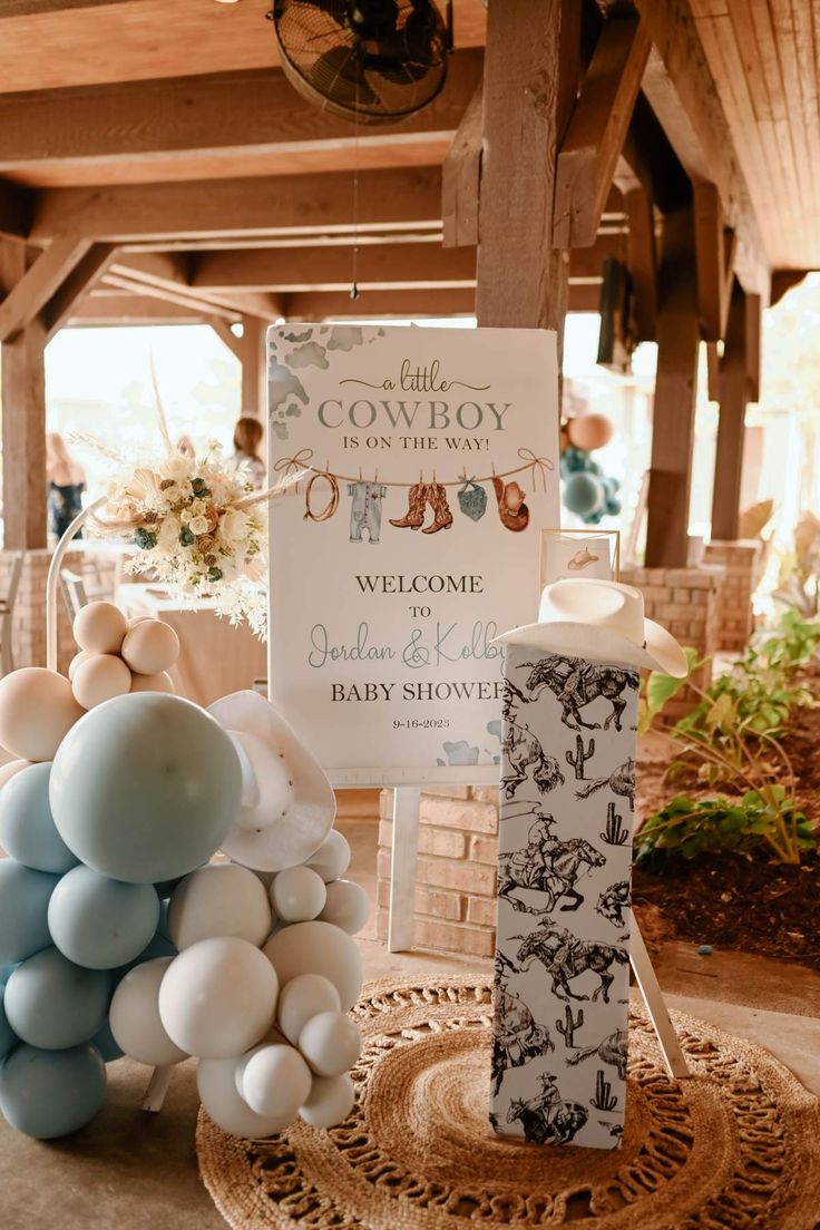 balloons are on display in front of a welcome sign for a baby shower at an outdoor event