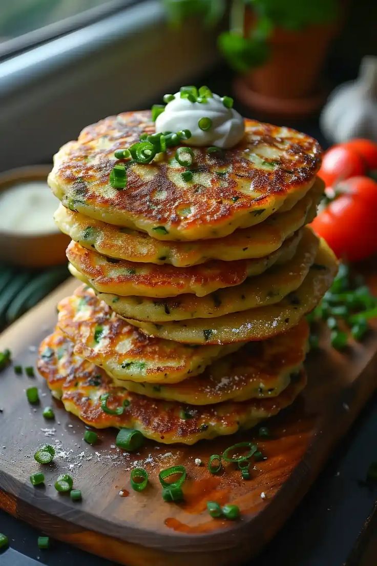 a stack of pancakes sitting on top of a wooden cutting board