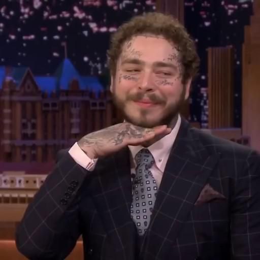 a man in a suit and tie on the tonight show with his hand to his chin