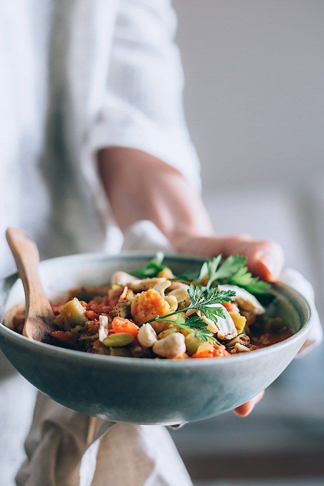 a person holding a bowl filled with food