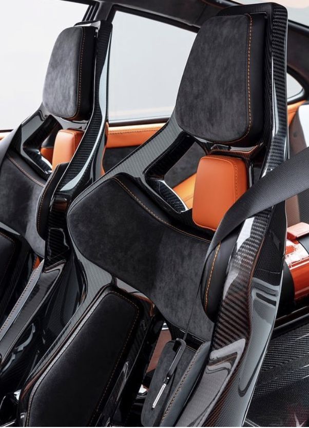 the interior of a sports car with black and orange leather trims, steering wheel covers and seats