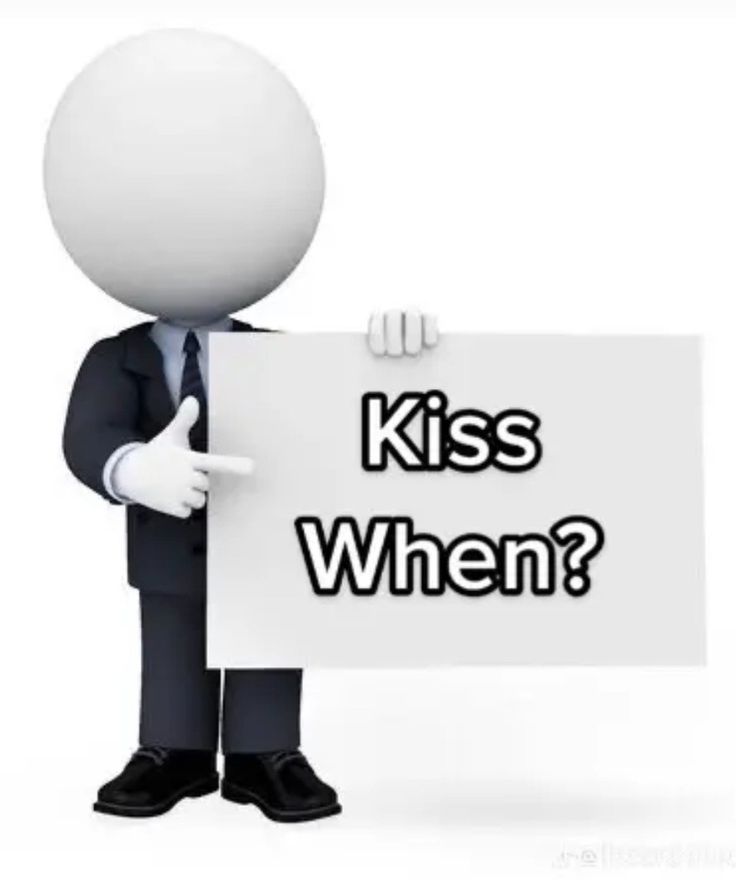 a man holding a sign that says kiss when? in front of him is the words