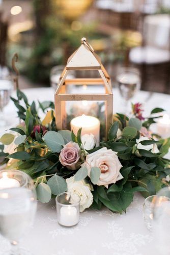 a table with candles and flowers on it is set up for an outdoor wedding reception