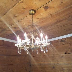 a chandelier hanging from the ceiling in a room with wood paneled walls