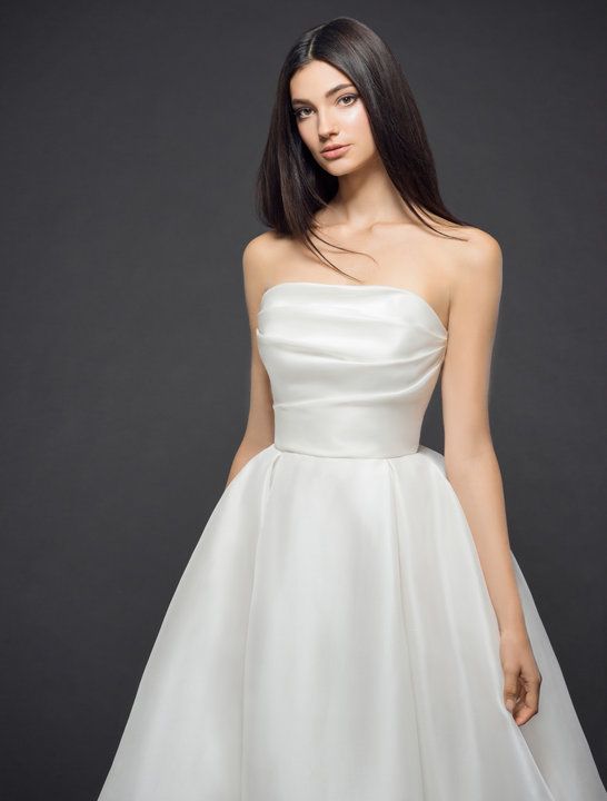 a woman in a white dress posing for the camera