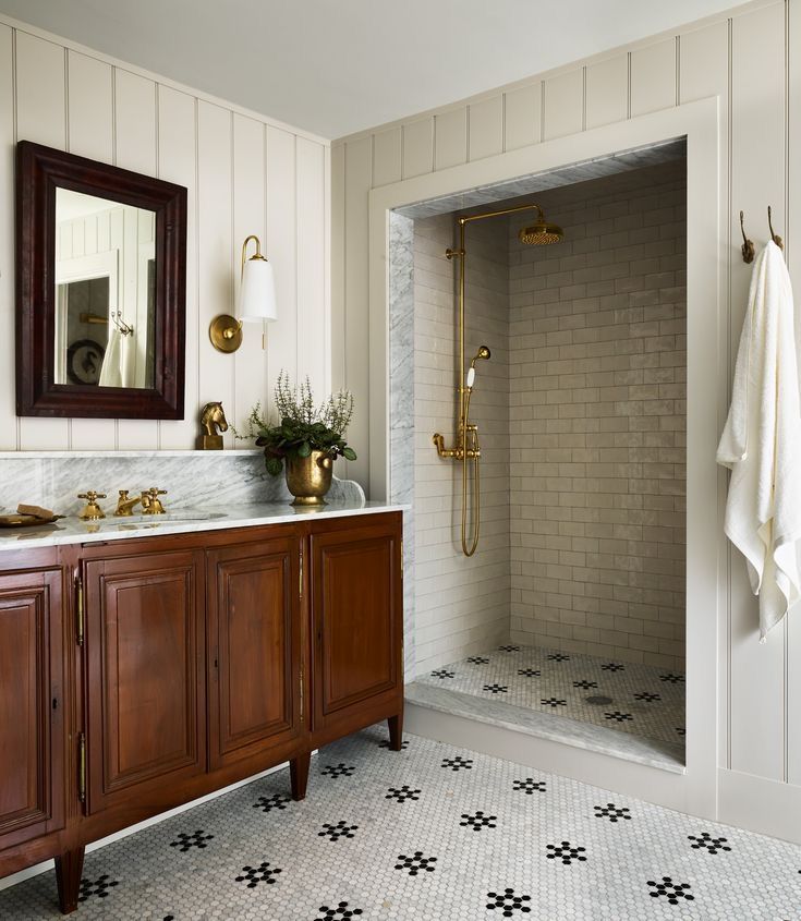 a bathroom with a sink, mirror and shower in it's center piece is shown