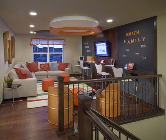 a living room filled with furniture and a chalkboard on the wall above it's stairs