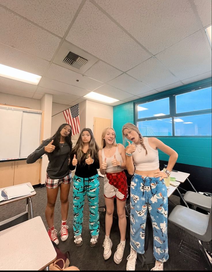 four girls standing in an office posing for the camera